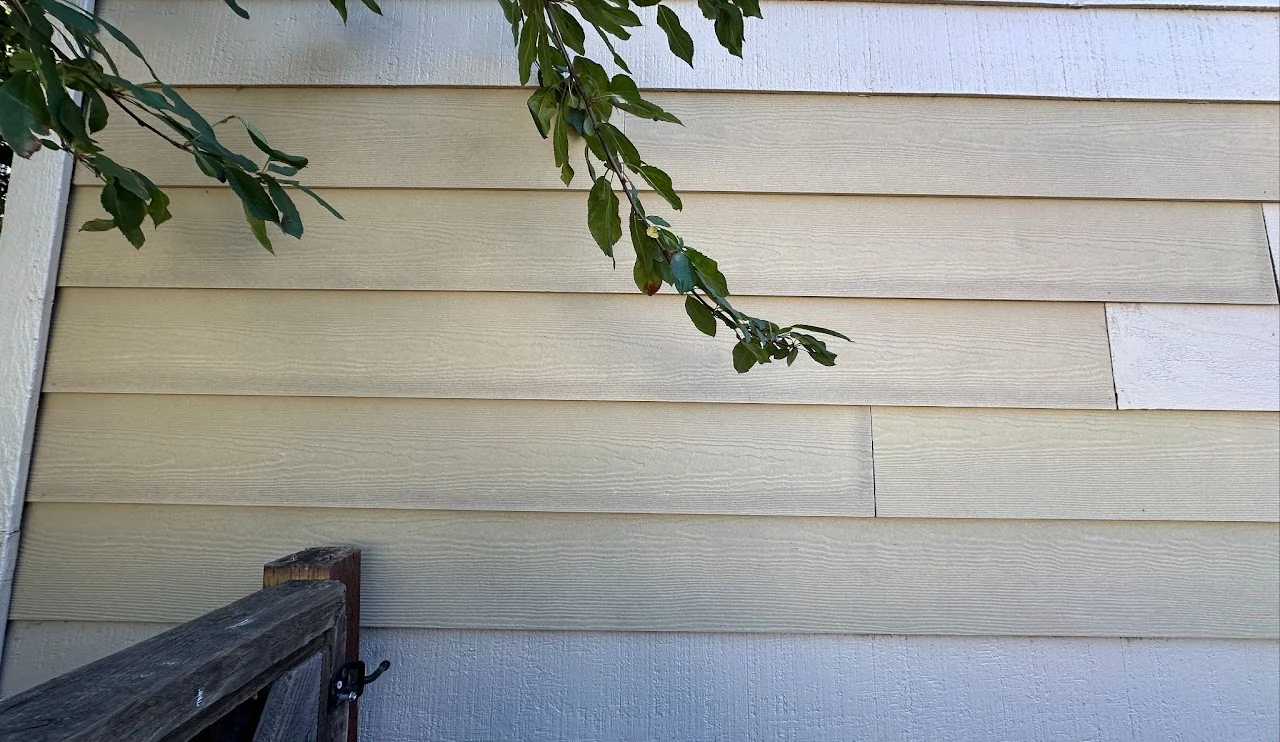 Exterior wall with horizontal siding beside a railing