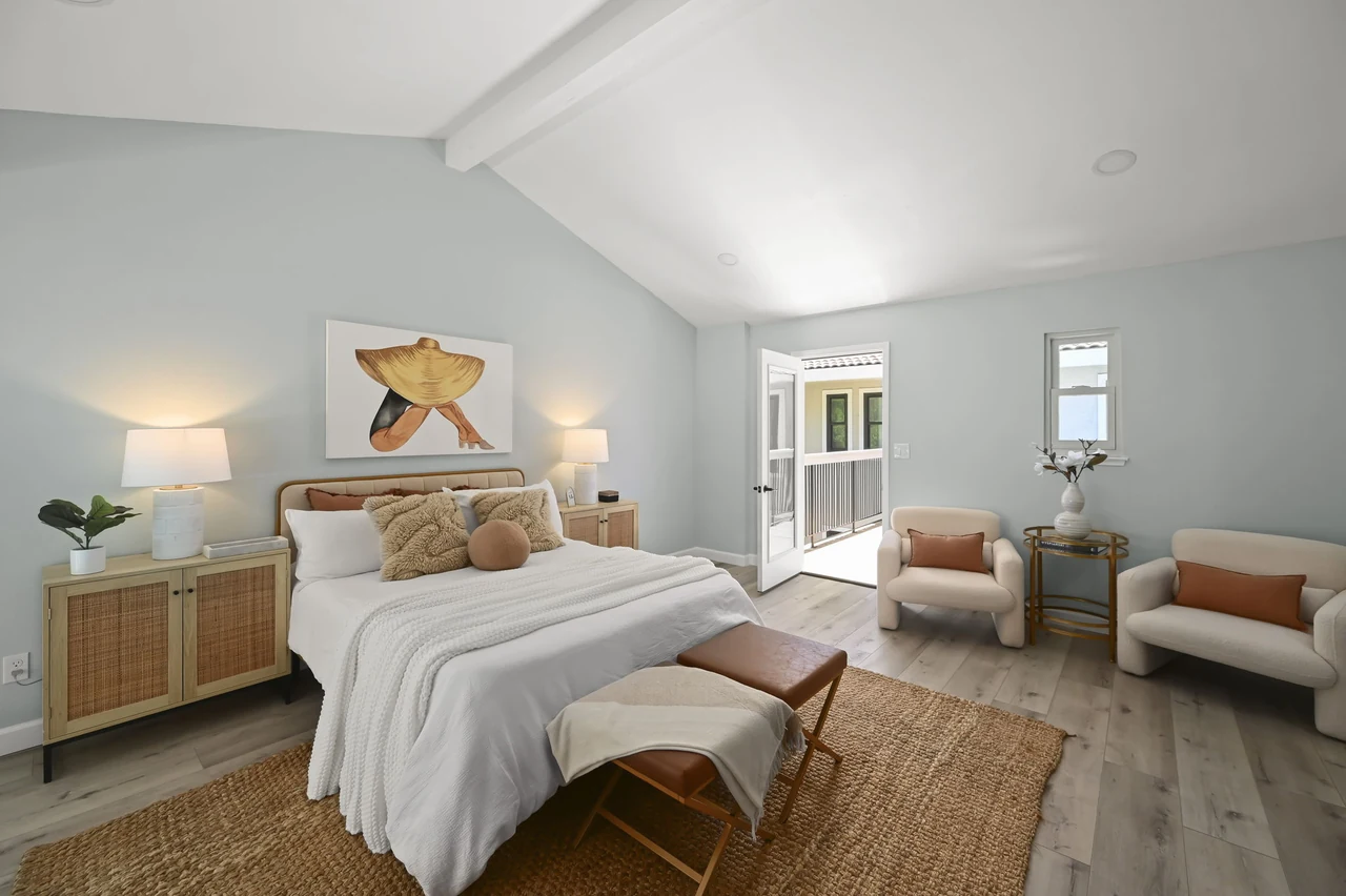 Guest suite with a bed, bedside tables, woven rug and sitting area