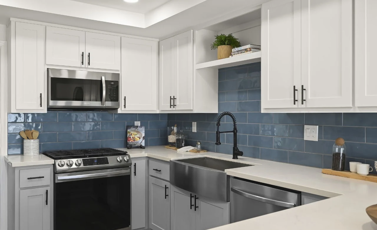 Kitchen with white cabinets, blue tile backsplash and stainless-steel appliances