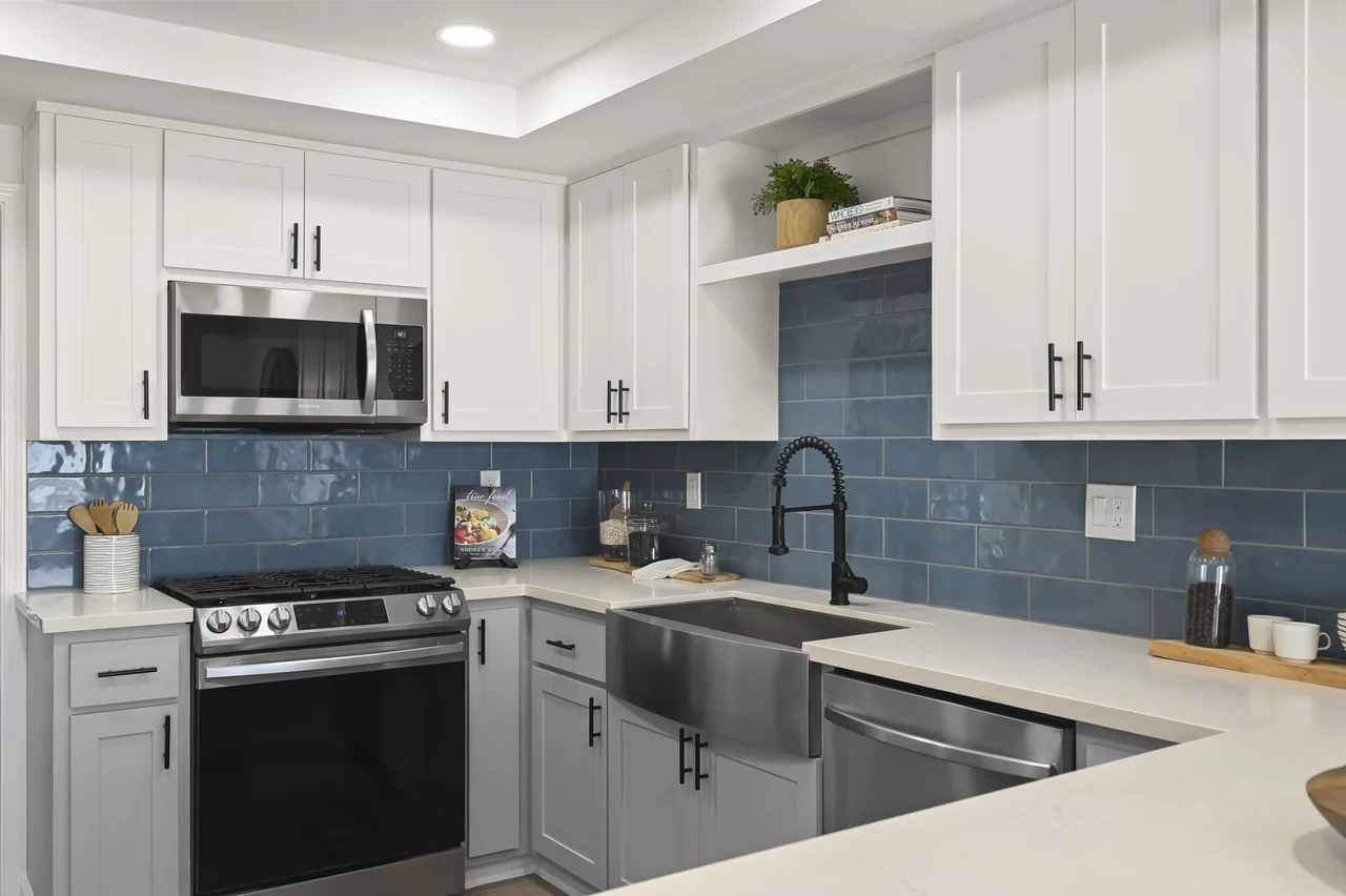 Kitchen with white cabinets, blue tile backsplash and stainless-steel appliances